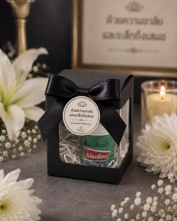 ของชำร่วยงานศพ Anatta — กล่องสีดำริบบิ้นสีดำ พร้อมพิมเสนน้ำสมุนไพร ติดสติ๊กเกอร์ชื่อผู้ล่วงลับ